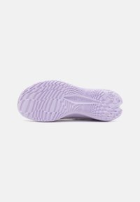 Lichtpaarse getextureerde zool van een Under Armour schoen, met zichtbare grippatroon en merklogo op een effen witte achtergrond.