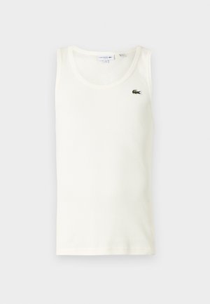 Camiseta sin mangas blanca con textura acanalada, escote redondo y un pequeño logo de cocodrilo verde en el lado izquierdo del pecho. Hecha de un material de algodón suave y elástico.