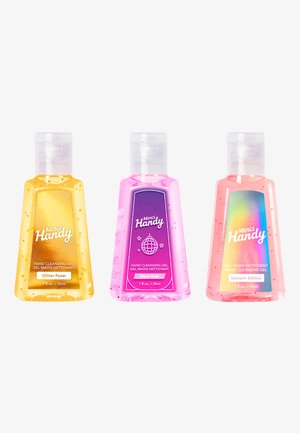 Trois flacons de gel nettoyant pour les mains de 30 ml : un jaune avec des paillettes, un rose avec un graphique de boule disco, et un rose irisé étiqueté "Édition Licorne."