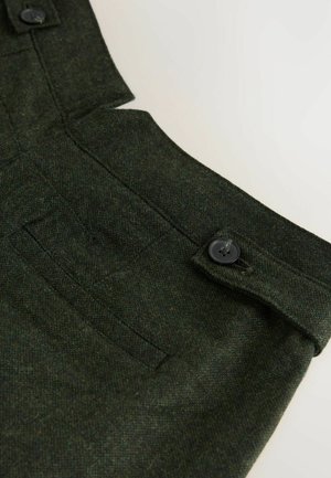 Tmavě zelená tkanina s texturovaným vzhledem, obsahuje zapínání na knoflík a boční kapsu v pase, zdůrazňující přizpůsobený design.