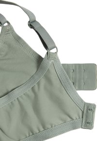 Sostén verde claro con tela suave, tirantes ajustables y cierre de gancho y ojo. Los detalles de costura realzan el diseño.