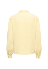Κίτρινη ελαφριά μπλούζα με υφασμάτινη υφή, μακριά μανίκια και μανσέτα με κουμπιά. Διαθέτει γιακά και χαλαρή εφαρμογή.