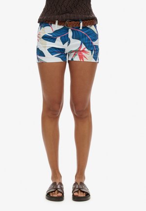 Geprinte shorts met een blauw tropisch bladontwerp op een witte achtergrond, met een effen tailleband en een bruine gevlochten riem.
