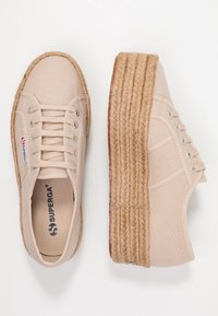 Sneakers platform beige in tela con suola in juta intrecciata, punta tonda e occhietti in metallo. Presentano un logo personalizzato sulla soletta.