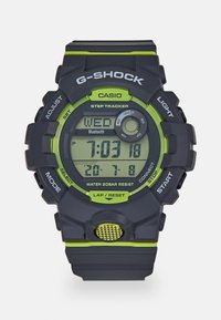 G-SHOCK Digitaluhr mit einem schwarzen und neongrünen Design, ausgestattet mit einem Schrittzähler, Bluetooth und einem wasserfesten Gehäuse, runden Tasten.