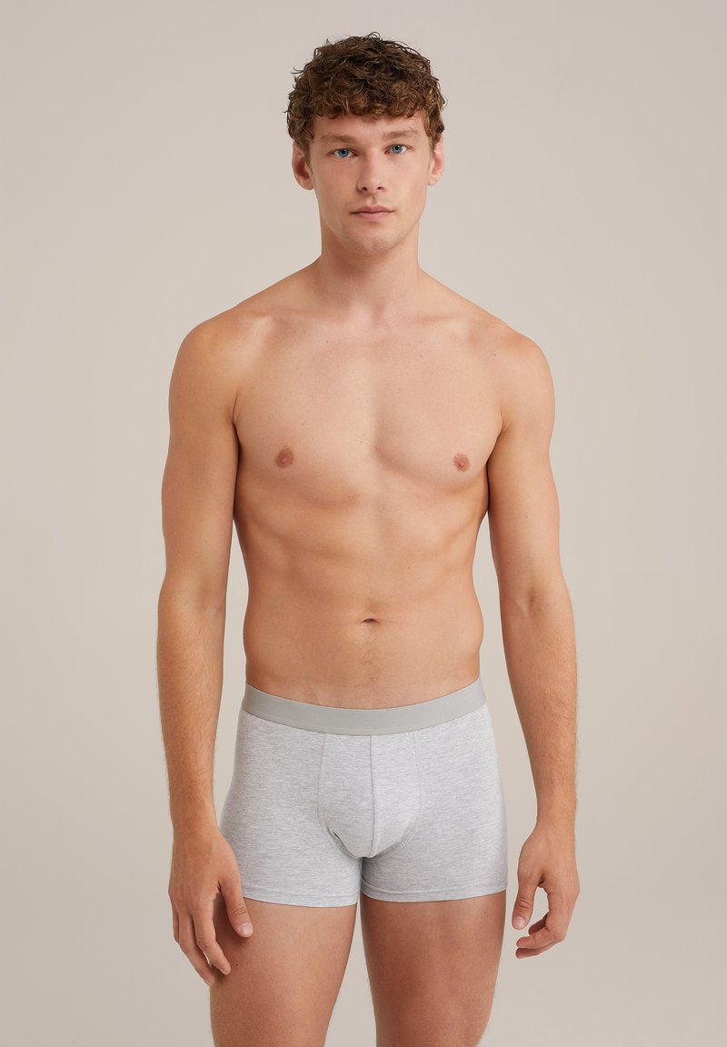 Grå boxertrosor med en mjuk textur, med en slät grå midja och en figursydd design, uppvisade på en modell.