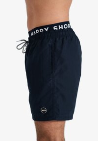 Marine zwemshorts met elastische tailleband, voorzien van de tekst "HAPPY SHORTS", een trekkoordsluiting en een zijzak; gemaakt van lichtgewicht materiaal.