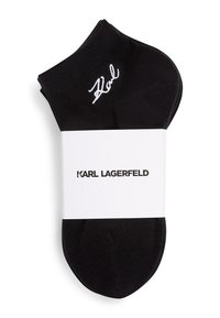 Calcetines negros hasta el tobillo hechos de tela de punto, con una firma bordada en blanco, empaquetados con una etiqueta de marca blanca que dice "Karl Lagerfeld."