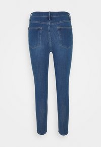 Jeans de mezclilla azul ajustados con una textura suave, que cuentan con una cintura de altura media, dos bolsillos traseros y un acabado limpio sin adornos.