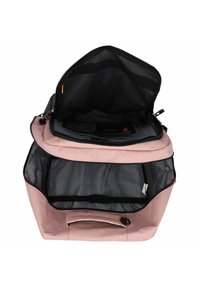 Sac à dos en tissu rose avec une grande ouverture, poche en maille noire à l'intérieur, bretelles réglables et une boucle pour sécuriser le contenu.