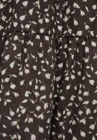 Brauner Stoff mit einem verstreuten Blumenmuster in zartem Grün, versehen mit einem gerafften Design und einer weichen Textur.