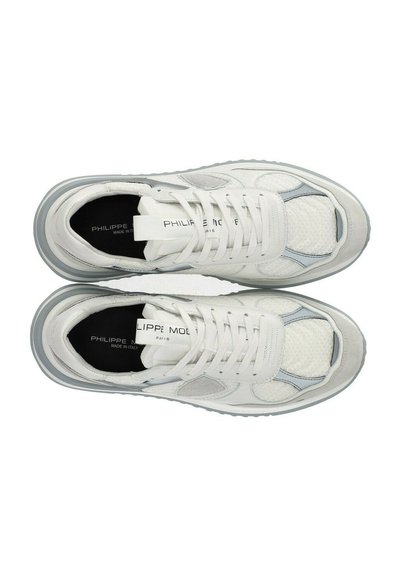 Baskets blanches mettant en avant un mélange de matériaux en cuir et en maille, avec une texture distinctive en forme de nid d'abeille, des accents gris et des lacets plats.