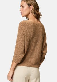 Maglione marrone a maglia con maniche a tre quarti, ampia scollatura a barca e tessuto testurizzato. La parte posteriore è leggermente più lunga di quella anteriore.