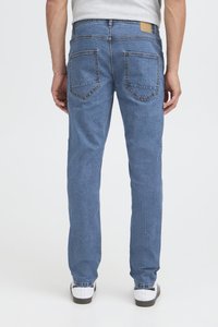 Džíny z džínoviny světle modré barvy, s rovnými nohavicemi, dvěma zadními kapsami a koženou nášivkou na pase. Hladká textura.