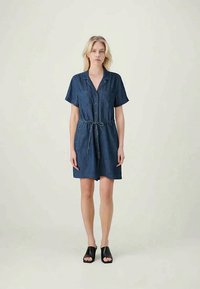 Rochie din denim cu mâneci scurte, cu deschidere cu nasturi pe față, talie legată și o siluetă lejeră. Culoare bleu închis și textură moale.