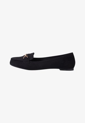 Loafers pour femmes en suède noir avec semelle plate et détail en métal doré en forme de boucle sur le dessus.