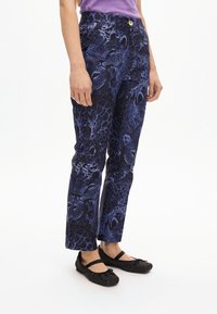 Pantaloni blu con motivo a stampa animale, a vestibilità slim con vita con bottone. Abbinate a ballerine nere scintillanti.