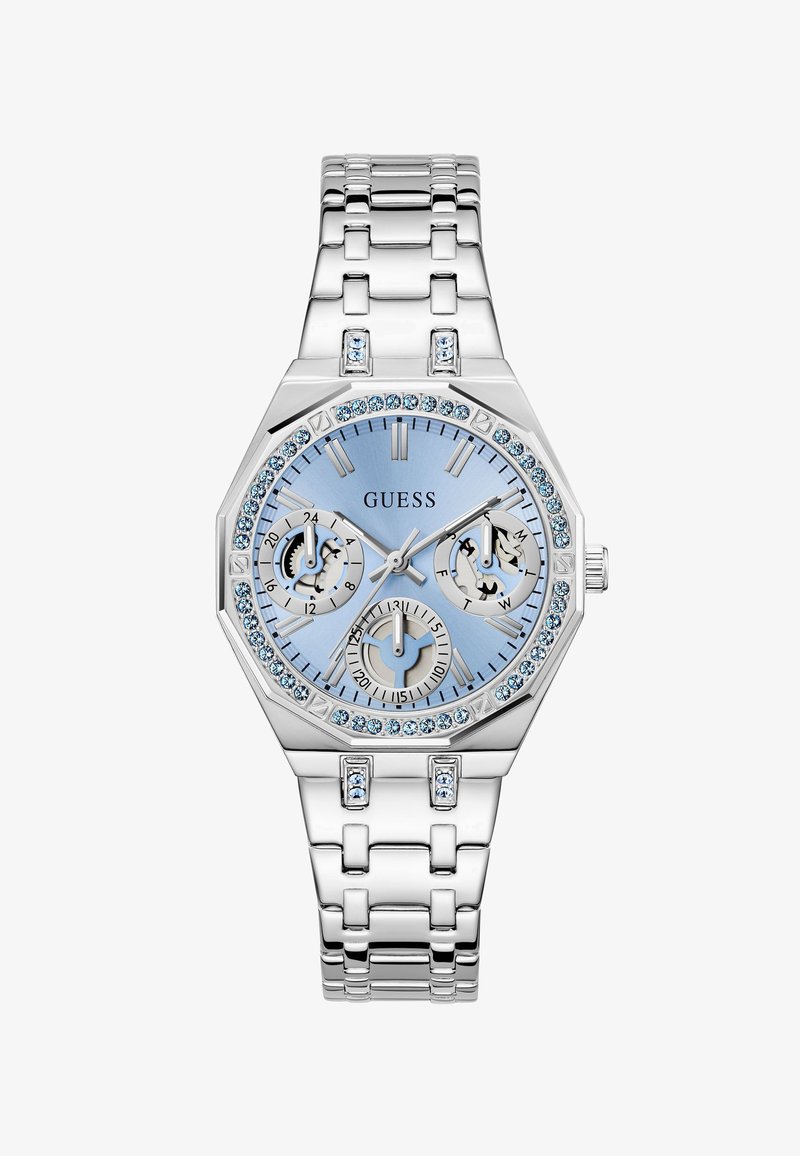 Montre Guess en argent avec cadran bleu clair, trois sous-cadrans et cristaux bleus autour de la lunette octogonale et des maillons du bracelet.