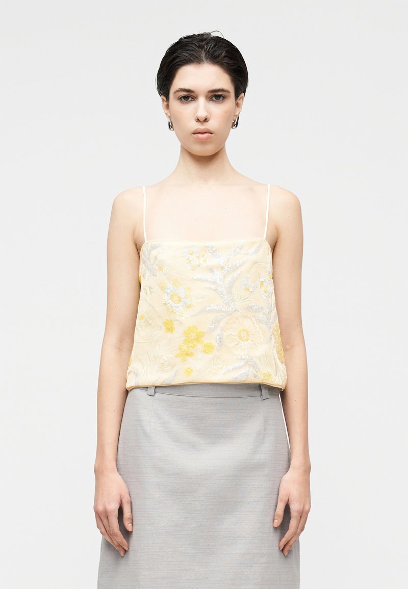 Κίτρινο κεντητό καμιζολέ με floral σχέδια και ασημένιες λεπτομέρειες, συνδυασμένο με ανοιχτό γκρι φούστα, με απαλό ύφασμα και λεπτές τιράντες.