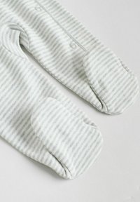 Salopetă pentru bebeluși, cu dungi de culoare gri deschis și alb, dintr-un material moale, cu închidere prin capse pe față și design cu picioare întregi, având vârfuri rotunjite.