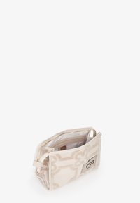 Borsa cosmetica in tessuto beige con motivo elegante, chiusura con zip, tasche interne e etichetta del logo. Forma rettangolare leggermente strutturata.