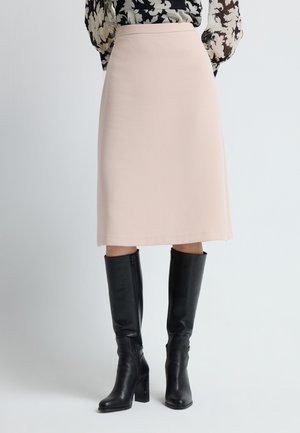 Lys rosa midi-nederdel med en glat tekstur og en tætsiddende talje, stylet med knæhøje sorte læderstøvler med en kraftig hæl.