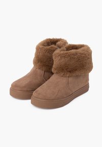 Botas de tobillo de ante marrón con un puño de piel, que cuentan con una suela de goma texturizada y un diseño simple para mayor comodidad y calidez.
