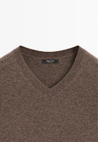 Brauner V-Ausschnitt-Pullover aus weichem Material; verfügt über einen gerippten Kragen und eine subtile Textur, Etikett im Nackenbereich sichtbar.