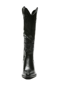 Bota de cowboy de cuero negro con punta afilada, costuras decorativas y un caña alta con un borde superior en forma de ondas y cremallera lateral.