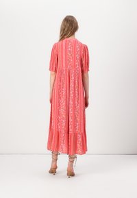 Long, pink floral dress with puff sleeves, tiered bottom, and vertical stripes. Fabric appears lightweight with a soft texture.