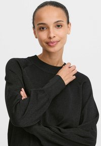 Schwarzer Pullover mit einer strukturierten, leicht glänzenden Oberfläche. Verfügt über einen runden Halsausschnitt und eine lockere Passform mit gerippten Bündchen und Saum.