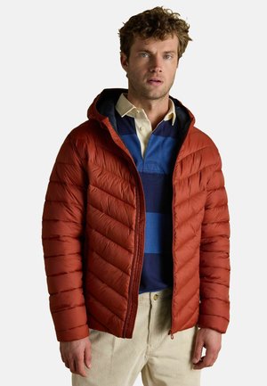 Red puffer jacket with horizontal quilted pattern and a hood, worn over a blue and white striped polo, featuring a zip closure and side pockets.