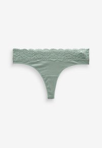 Tanga u mint zelenoj boji s čipkastim pojasom. Mekani materijal, čipkasti detalji sa valovitim rubovima i dizajn s minimalnom pokrivenošću. Glatka tekstura kroz cijeli komad.