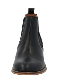 Botín Chelsea de cuero negro con paneles elásticos en los laterales, punta redonda y suela marrón. Presenta una lengüeta en el talón para facilitar el uso. Textura suave.