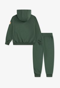 Hoodie vert avec une poche kangourou et des poignets côtelés, associé à un jogging assorti avec une taille élastique et des poignets de cheville.