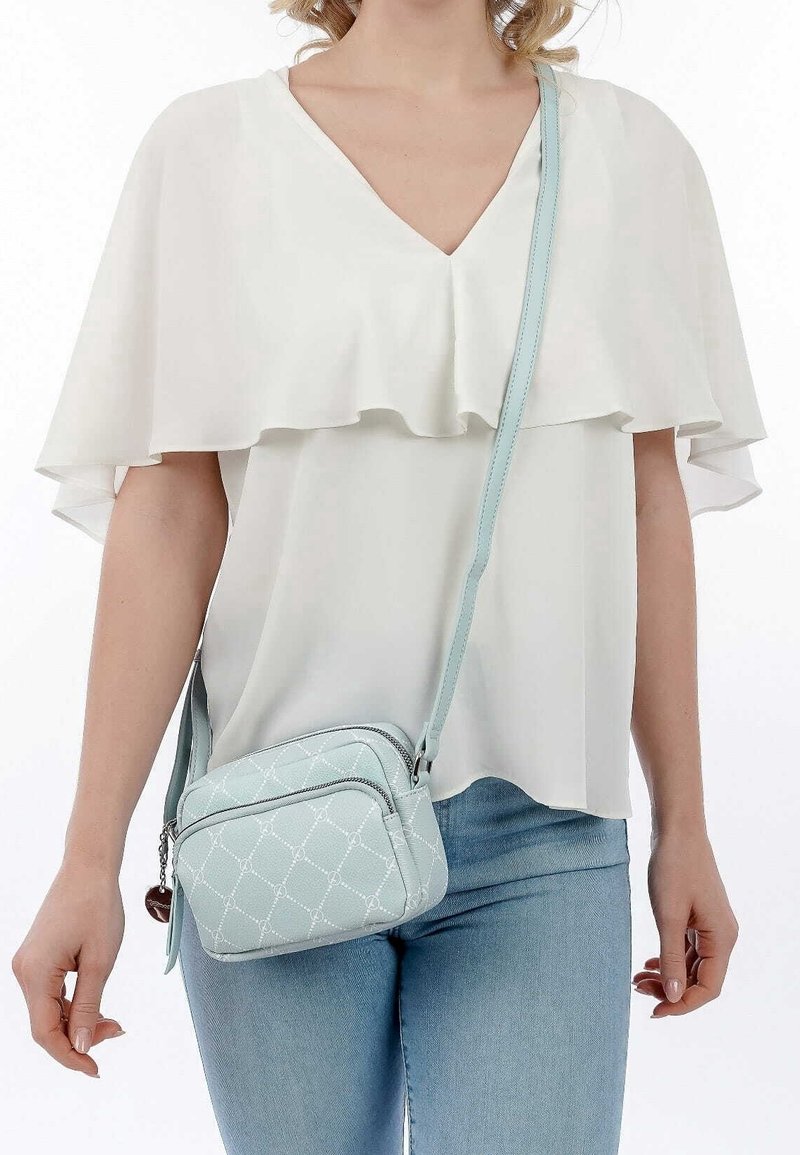 Borsa a tracolla azzurro chiaro con design trapuntato e hardware in argento. Presenta una chiusura con zip e una lunga tracolla regolabile.