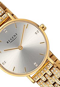 Montre à tons dorés avec un cadran argenté, design minimaliste, marqueurs d'heure en cristal et un bracelet en métal texturé comportant des maillons rectangulaires.