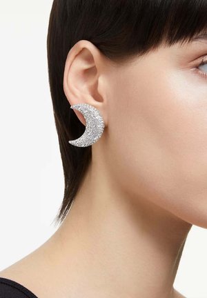 Silver crescent-shaped earrings adorned with clear rhinestones, featuring a textured surface, showcased against a neutral background.