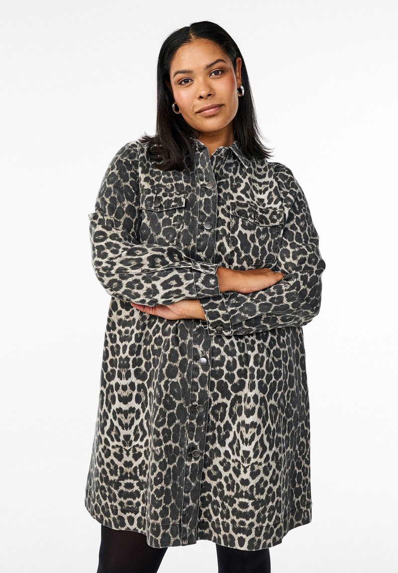 Vestido camisolín de mezclilla con estampado de leopardo, que cuenta con un cierre frontal de botones, dos bolsillos en el pecho, mangas largas y un corte relajado.
