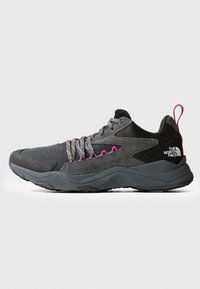Zapatilla de perfil bajo negra y gris con acentos en rosa, cordones con diseño y el logo de The North Face en el talón, mostrada en vista lateral.