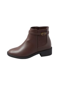 Botín de cuero marrón hasta el tobillo con un acabado suave, con cremallera lateral, una correa decorativa con hebilla dorada y un tacón bajo tipo bloque.