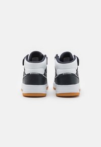 Wysokie trampki z białą cholewką, granatowymi akcentami i gumową podeszwą. Posiadają wyściełany kołnierz i pasek na pięcie dla wsparcia.