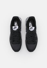 Sneaker Nike Internationalist neri con tomaia in mesh testurizzato, lacci neri e dettagli bianchi sui lati e sulla suola.