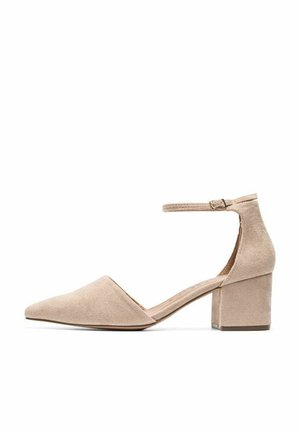 Beige ruskindsblokhæle med spids tå, ankelrem og struktureret finish, som har en moderat hælhøjde og en elegant silhuet.