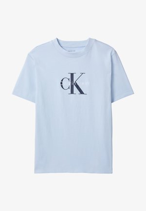 Lyseblå t-shirt med korte ærmer med stort sort "cK" og hvidt "Calvin Klein" logo centreret på forsiden.