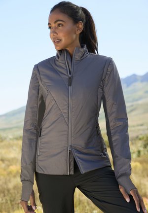 Graue isolierte Jacke mit hohem Kragen, geometrischer Naht, Reißverschluss vorne und langen Ärmeln. Ausgestattet mit enganliegenden Manschetten und Seitentaschen.