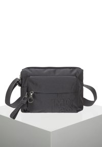 Borsa a tracolla nera in tessuto con superficie texturizzata, tasca frontale con zip, tracolla regolabile e dettaglio del logo. Forma compatta e rettangolare.