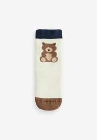 Calze in tessuto crema con bordo a coste blu navy e design di orso marrone. Presentano una punta e un tallone marroni con una texture morbida.
