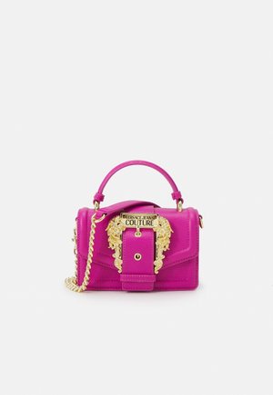 Bolso de mano rosa brillante con asa superior, correa de cadena dorada y hebilla ornamentada de oro con la etiqueta "Versace Jeans Couture" en la solapa frontal.