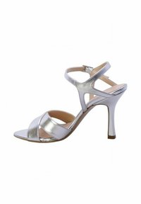 Sandali alti metallici argentati con cinturini incrociati e fibbia alla caviglia. Presentano un design elegante con punta aperta e tacco a stiletto.